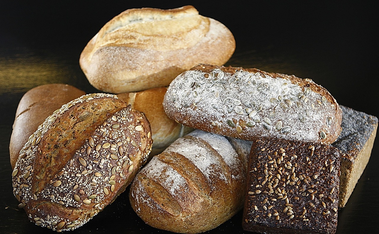 Varie pagnotte di pane salutare esposte in un supermercato, con etichette nutrizionali visibili.